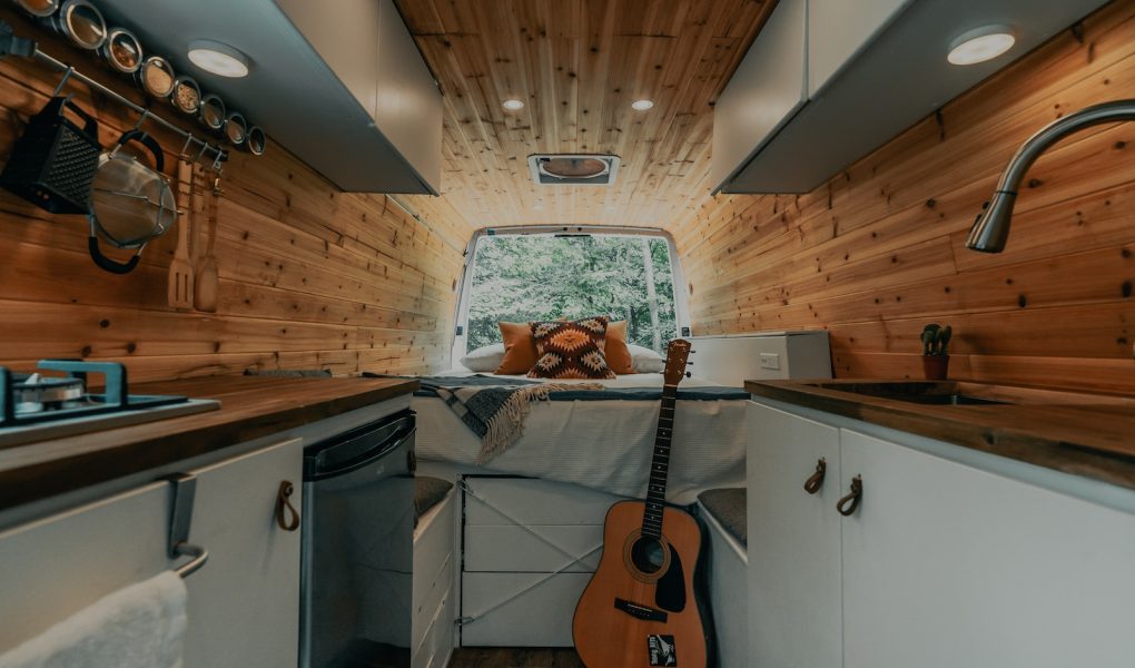 brown acoustic guitar on black steel stand