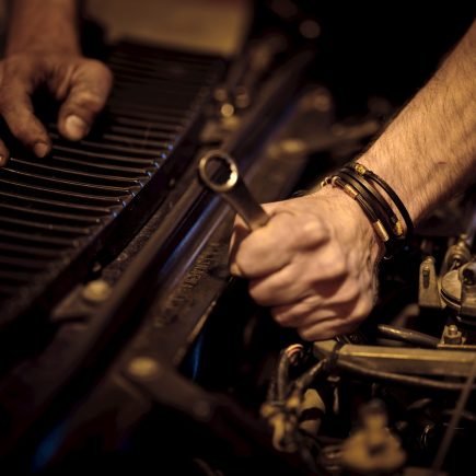 grayscale photo of person playing piano