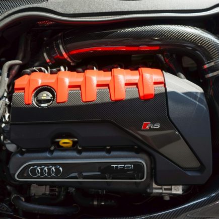 a close up of a car engine with an orange engine cover
