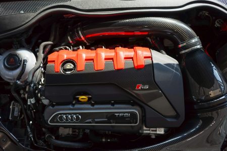 a close up of a car engine with an orange engine cover